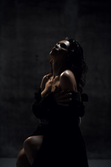 Young sensual beautiful sexy woman posing in spring fashion body jacket and expensive jewelry naked on dark 