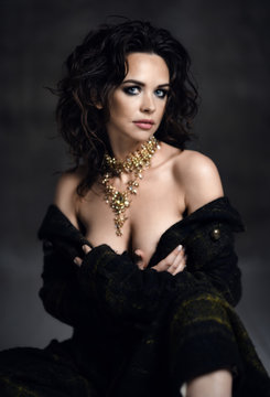 Young sensual beautiful sexy woman posing in spring fashion body jacket and expensive jewelry naked on dark 