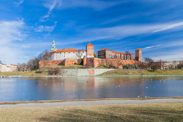 Naklejka na ściany i meble POLAND, KRAKOW - FEBRUARY 23, 2019: Wawel Castle, a view from the Vistula River. Blue sky and cloud. Gothic cathedral Polish architecture.