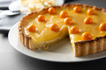 Lemon curd pie. Piece, slice of homemade delicious pie ,tart filled with lemon curd. Sweet dessert. Lemon curd pie decorated with physalis.