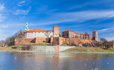 Fototapeta na wymiar POLAND, KRAKOW - FEBRUARY 23, 2019: Wawel Castle, a view from the Vistula River. Blue sky and cloud. Gothic cathedral Polish architecture.