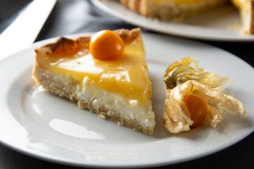 Lemon curd pie. Piece, slice of homemade delicious pie ,tart filled with lemon curd. Sweet dessert. Lemon curd pie decorated with physalis.