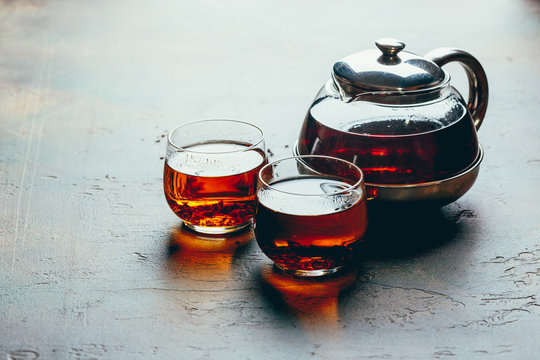 Transparent glass teapot black tea and glass cups