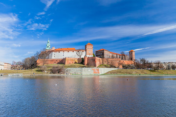 Fototapeta premium POLAND, KRAKOW - FEBRUARY 23, 2019: Wawel Castle, a view from the Vistula River. Blue sky and cloud. Gothic cathedral Polish architecture.