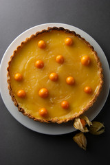 Lemon curd pie. Homemade delicious pie ,tart filled with lemon curd. Sweet dessert. Lemon curd pie decorated with physalis.