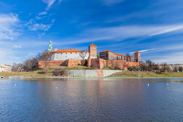 Fototapeta premium POLAND, KRAKOW - FEBRUARY 23, 2019: Wawel Castle, a view from the Vistula River. Blue sky and cloud. Gothic cathedral Polish architecture.
