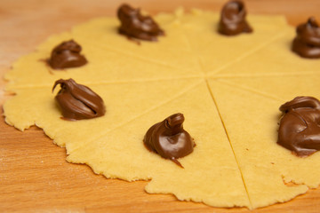 Making mini homemade croissants rolls, pastry puf. Uncooked chocolate croissants. French pastry goods.