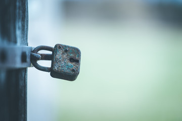 Rusty old padlock at a door, close up