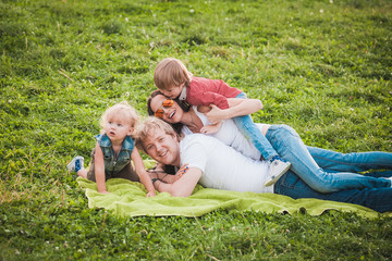 Naklejka na ściany i meble Happy family together in green park in summer