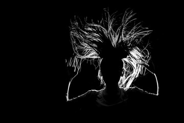 art picture of a funny girl jumping in flight with her hair down to her sides in contrasting light...
