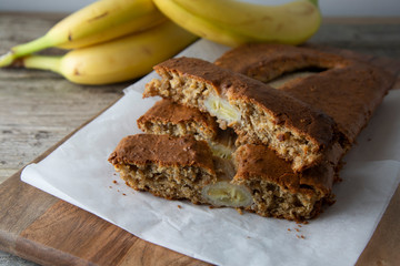 Banana bread with oat flour. Top view of homemade banana bread on wooden background. Ideas and recipes for healthy diet breakfast.