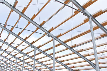 Wooden beams on a metal frame. Construction of agricultural buildings. The construction of the barn. Agriculture.