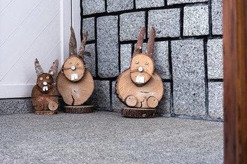 At the front door of the house there are three wooden rabbits.