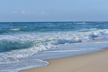 Sea, Blue waves with white foam, under the blue sky.