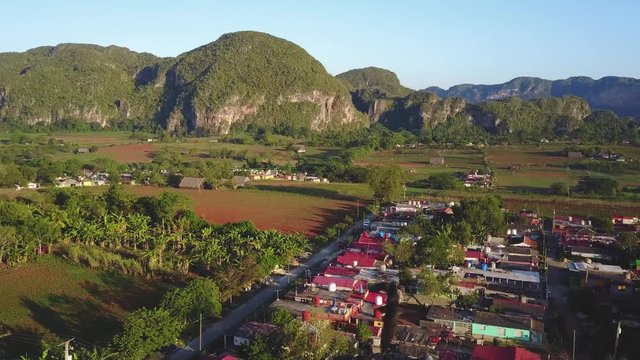 Reverse over town with green mountains in Vinales, Cuba
