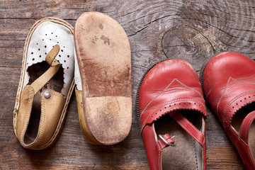 Children oldfashioned shoes on vintage wood background closeup. Reminder of childhood