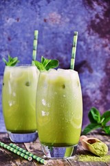 Homemade matcha and almond milk iced latte on light blue concrete background - Image 
