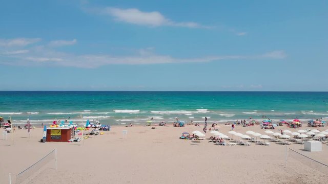 Ascending Aerial footage of a summery mid-day beachfront at Alicante, Spain