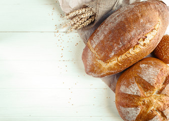 Assortment of baked bread on wooden table background