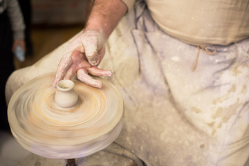 Potter's hands at work close-up. Potter working clay on potter's wheel. Craft, hobby