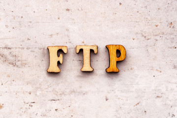 Inscription ftp File Transfer Protocol abbreviation in wooden letters on a light background