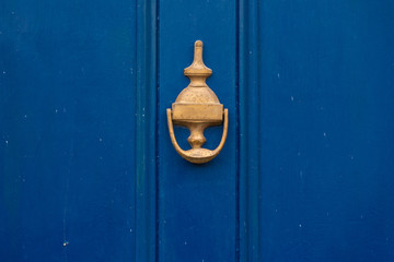 Background of vintage blue painted door and knocker vignette look made of old fashioned vintage brass metal