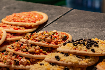 Many small hot pizzas on sale at a street market