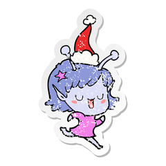 happy alien girl distressed sticker cartoon of a wearing santa hat