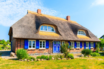 Fototapeta na wymiar Traditional house with straw roof and sunny blue sky in Middelhagen village, Ruegen island, Baltic Sea, Germany
