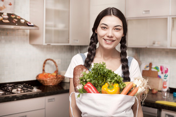 woman holding grocery bag at the kitchen