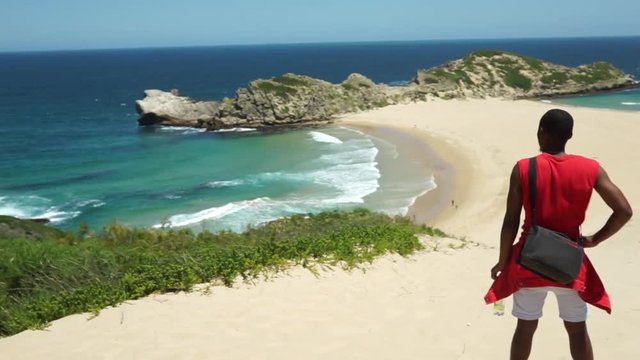 Young guy looking out to Robberg beach, Plettenberg Bay, South Africa.