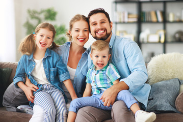 happy family mother father and kids at home on couch.