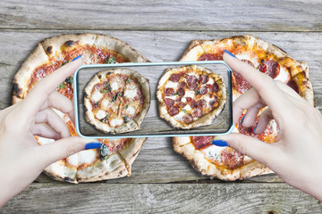 Woman photographing her homemade pizza with smartphone, food photography concept