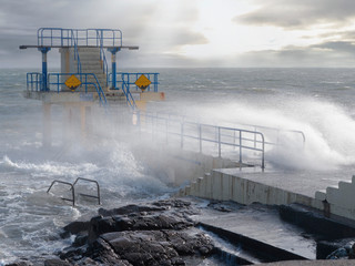 Waves crushing on Blackrock diving board during a storm. Salthill promenade, Galway city, Ireland....