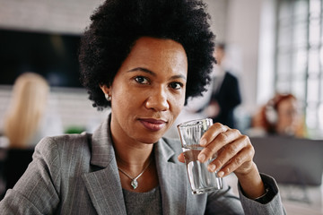 African American businesswoman having a glass of water while working in the office.