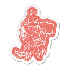 cartoon distressed sticker of a wolf with sign post showing teeth wearing santa hat