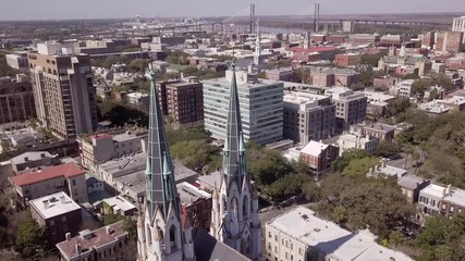Aerial backing away shot of downtown Savannah, Georgia with Cathedral of St John in foreground.