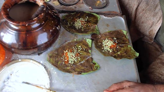 Street vendor making paan masala for his customers using paan leaf, betel nut or areca nut, calcium hydroxide, cardamon, cloves and gulkand.