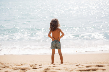 Little five years old boy is watching on the sea 