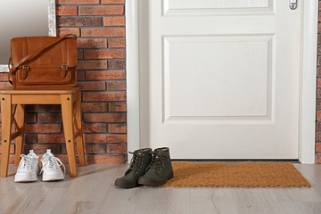 Hallway interior with shoes, bag and mat near door