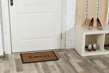 Hallway interior with shoe rack and mat near door