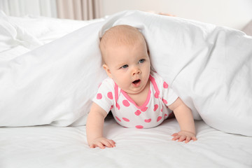 Cute baby girl in bed at home. Bedtime schedule