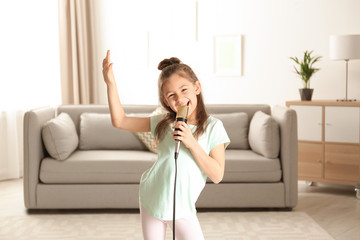 Cute funny girl with microphone in living room