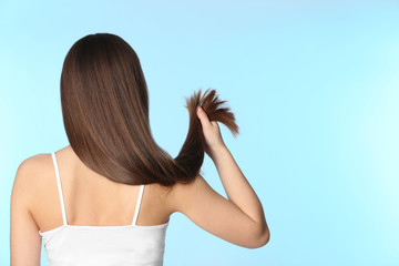 Woman with long brown hair on color background. Space for text