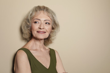 Portrait of mature woman on color background. Space for text