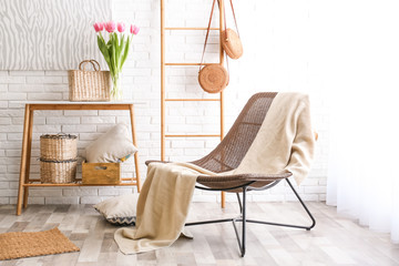 Stylish living room interior with cozy armchair near brick wall
