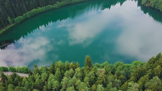hd aerial drone dolly sideways, over forest, blue lake reflecting sky and clouds, sunny weather, in Artvin Savsat Karagol, Turkey