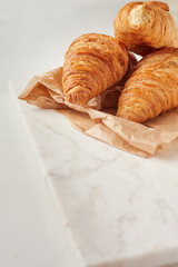 Croissants on the parchment paper, on the marbel board