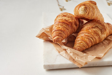 Croissants on the parchment paper, on the marbel board