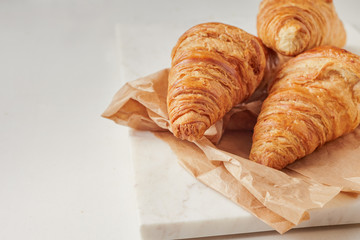 Croissants on the parchment paper, on the marbel board